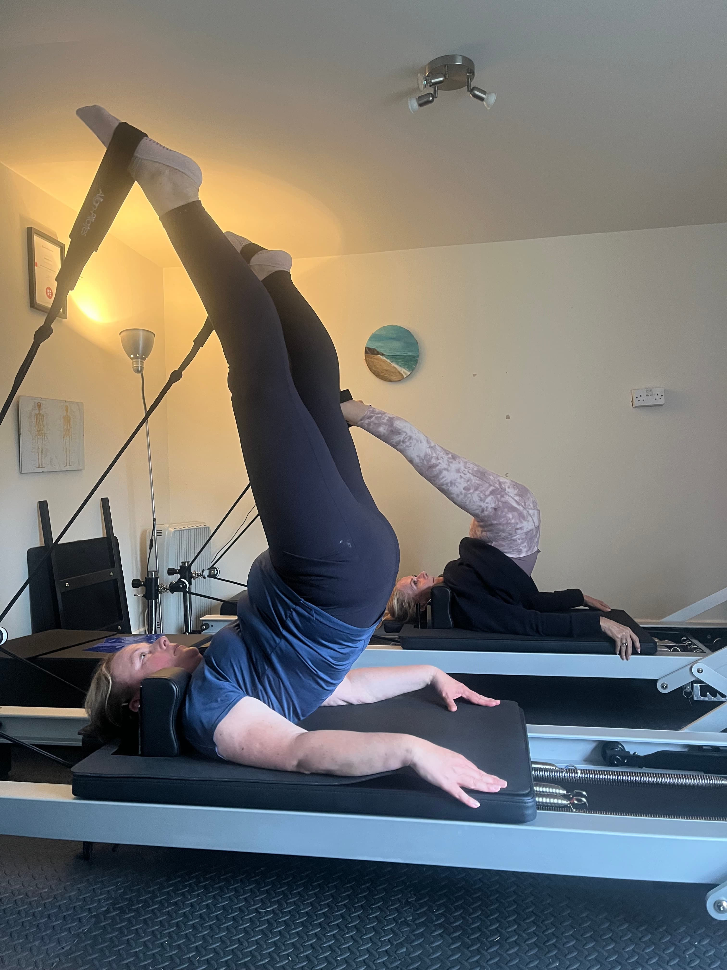 Clients working side by side on reformers in the Cornish Core Pilates studio
