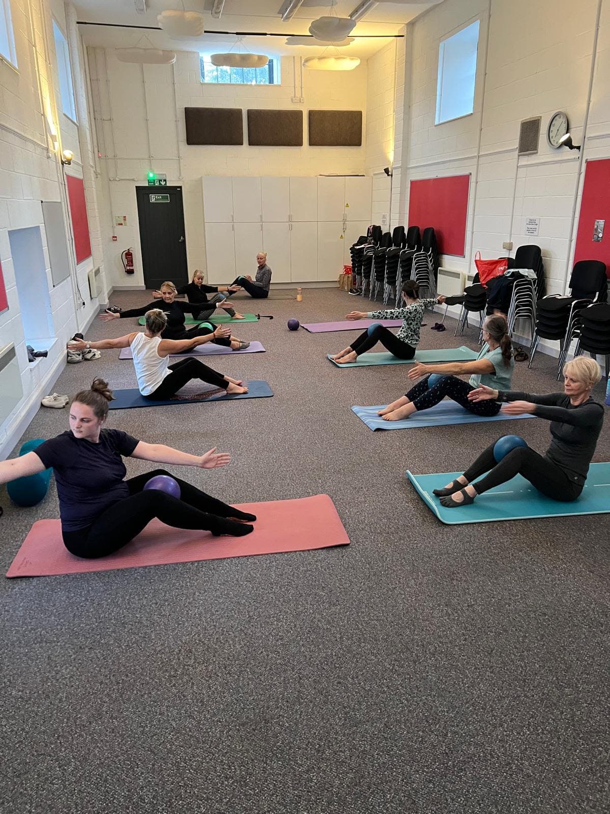 Mat Pilates class working through a seated spine twist at The Pattern Hall, Charlestown